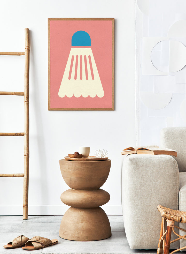 Shuttlecock with blue top and white body on a pink background. Badminton White Blue by Rosi Feist is a modern sports wall art print featuring a minimalist shuttlecock design in bold color and graphic poster style.