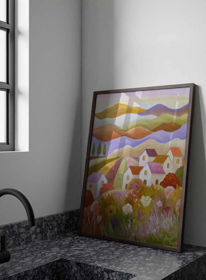 A colorful landscape painting featuring rolling hills, stylized houses, cypress trees, and wildflowers in the foreground, rendered in a painterly impressionistic style. Shop Colorful Countryside Village by Angeles M. Pomata, an autumn landscape art print featuring white houses, rolling hills, wildflowers, and warm earthy tones.