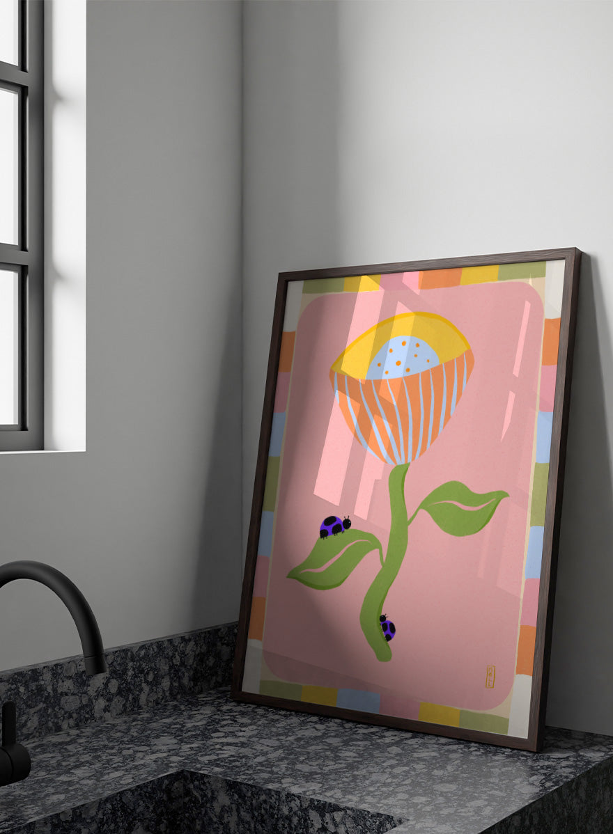 A stylized art print featuring a large flower with a yellow and orange striped bloom, green stem and leaves, and two ladybugs on a pink background with a multicolor border. Shop Pastel Flower Ladybugs by Dirkie Nell, a playful floral and insect art print featuring an oversized pastel flower, purple ladybugs, and a colorful retro border.