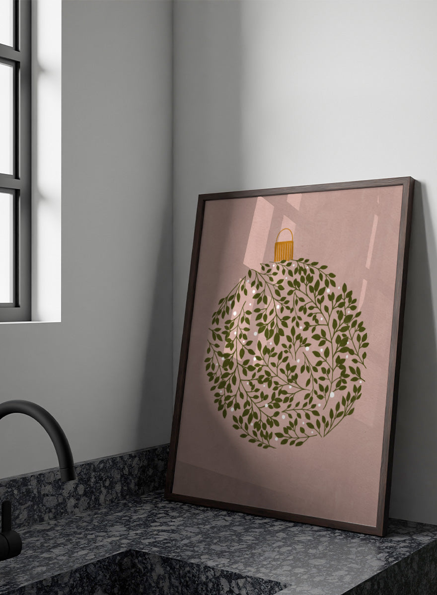 Shop Round Ornament by Katie O’Shea, a botanical Christmas wall art print poster featuring green leaves, white glowing light details, and a dusty pink background.