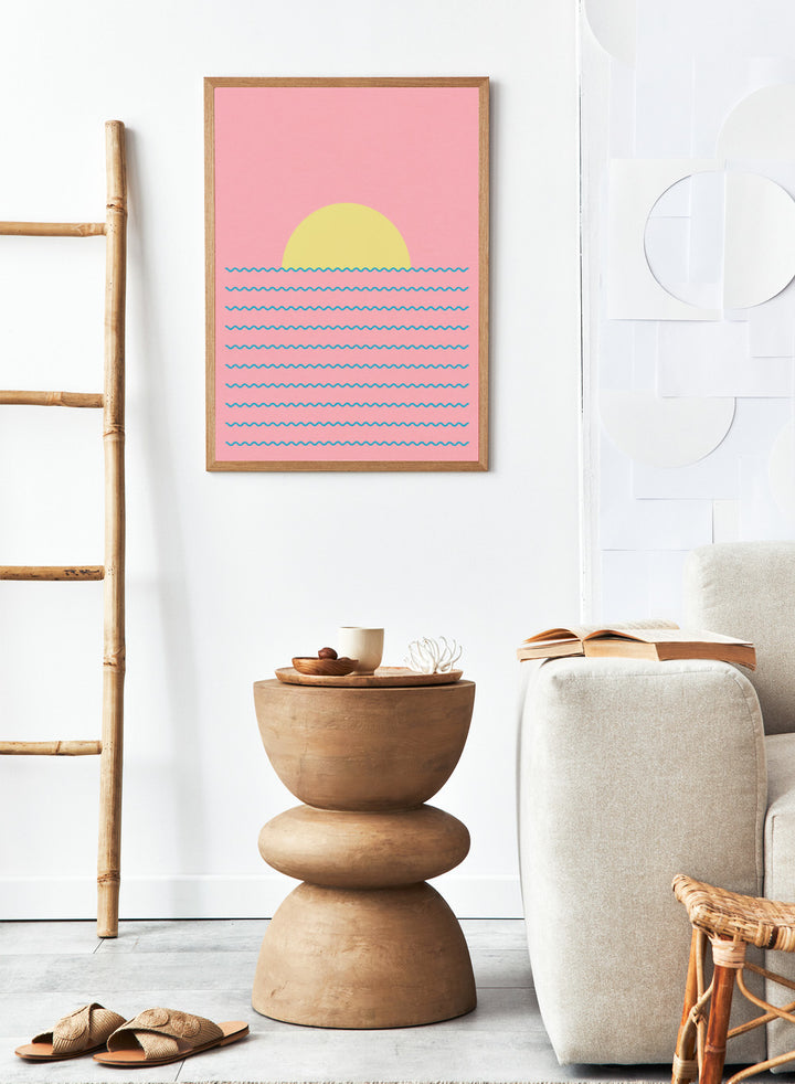 Simplified illustration of a sunset over water with blue waves on a pink background. Every Day the Sun Rises by Rosi Feist is a minimalist sun and waves art print with pink sky. Officially licensed modern poster with framing.