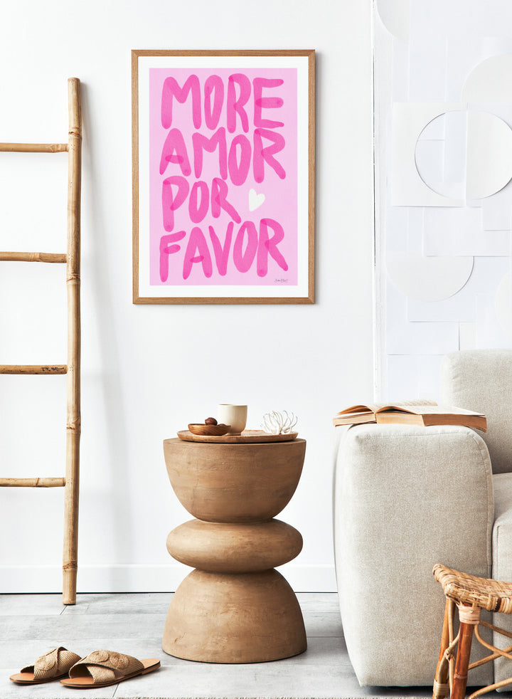 Pink text 'More Amor Por Favor' with a heart on a pink background. More Amor Por Favor by Baroo Bloom features bold pink hand-painted typography and a playful love message. Officially licensed wall poster with optional framing.