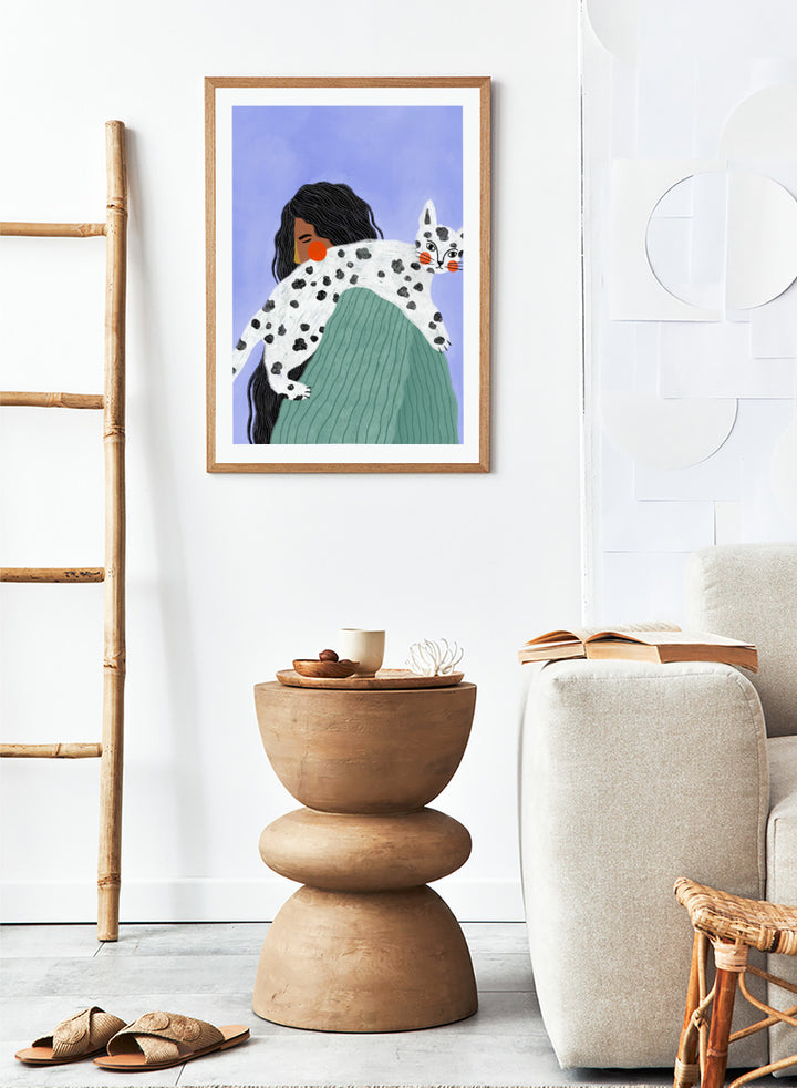 A framed art print featuring a stylized illustration of a woman with long black hair carrying a white cat with black spots over her shoulder, set against a lavender background. Woman and Spotted Cat by Bea Müller animal art print featuring a woman carrying a playful spotted cat, perfect for modern cat lover and pet decor.