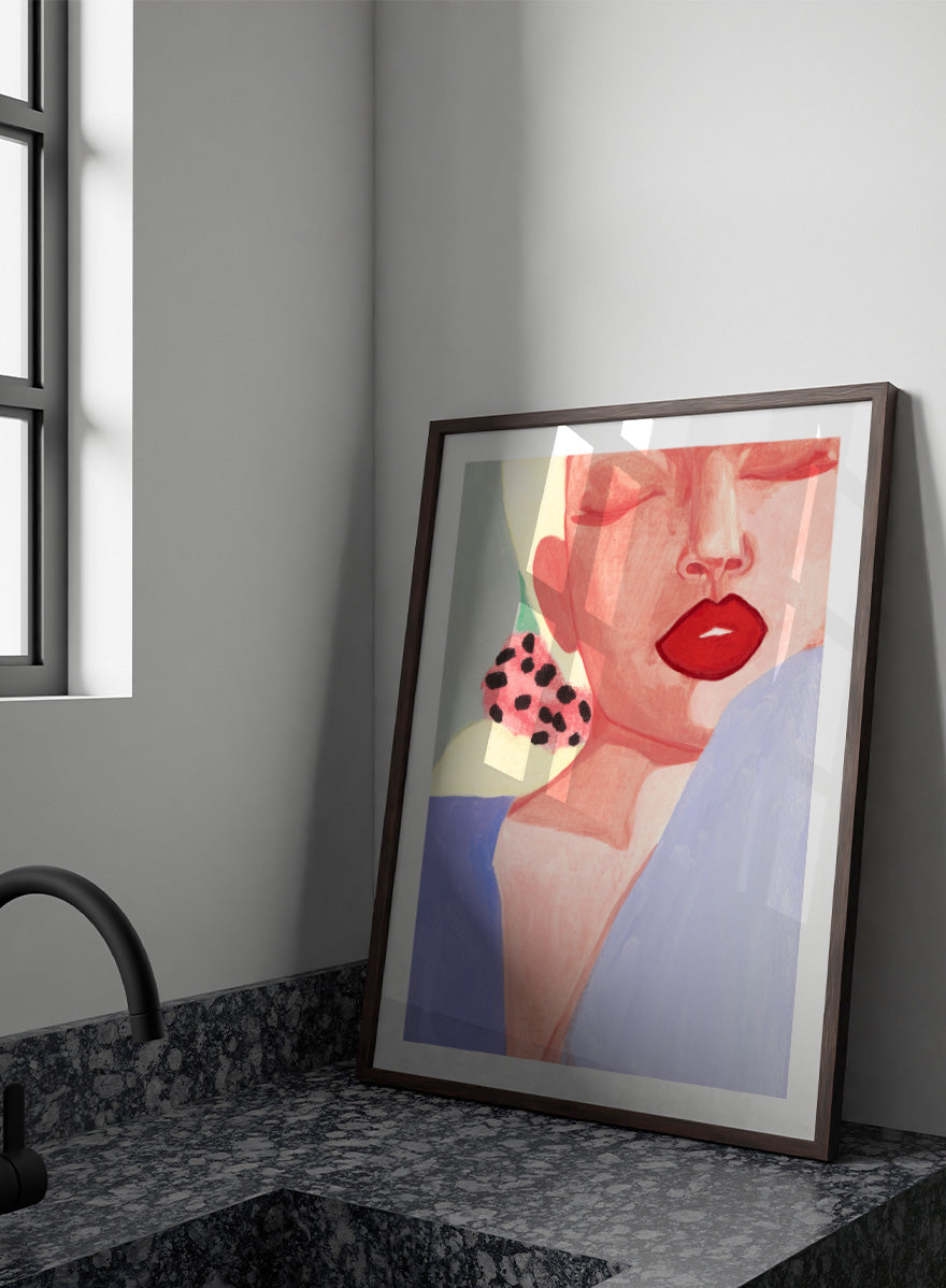 Shop Red Lips by Sophia Novosel, a modern woman portrait wall art print poster featuring bold red lips, closed eyes, soft pink tones, and a spotted earring.