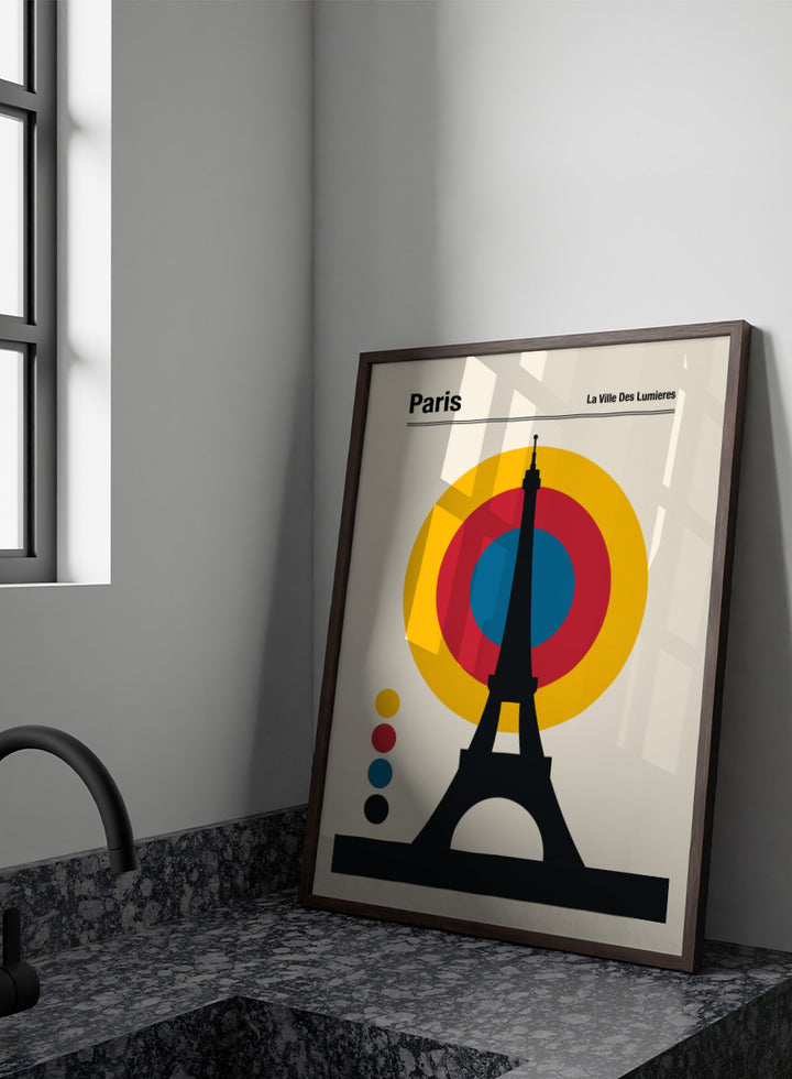 A minimalist Paris poster featuring a black Eiffel Tower silhouette in front of concentric yellow, red, and blue circles on a cream background, with the text &