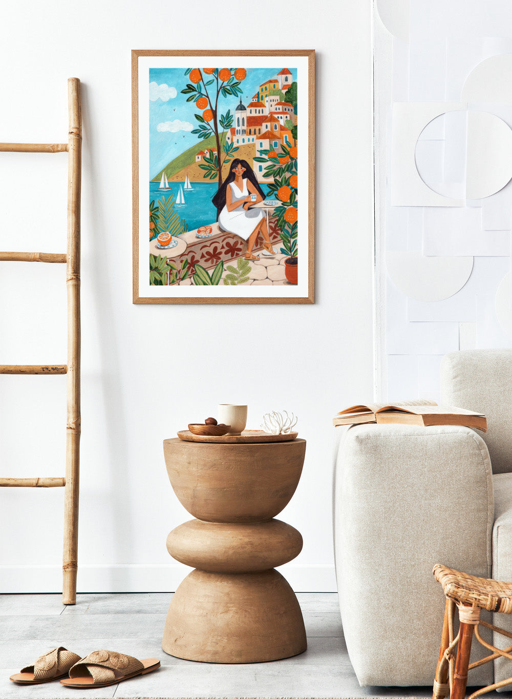 Woman in a white dress sitting under an orange tree with a scenic coastal town in the background. Mediterranean Orange Grove View by Caroline Bonne Müller fine art print, wall art poster with coastal scene, orange trees, modern aesthetic design