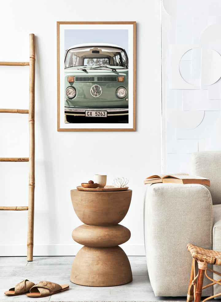 Front view of a vintage green Volkswagen van with clear sky background. Classic Design In Soft Green Tones by Shot by Clint car art print featuring a vintage Volkswagen camper van in soft sage green and warm sunlight.