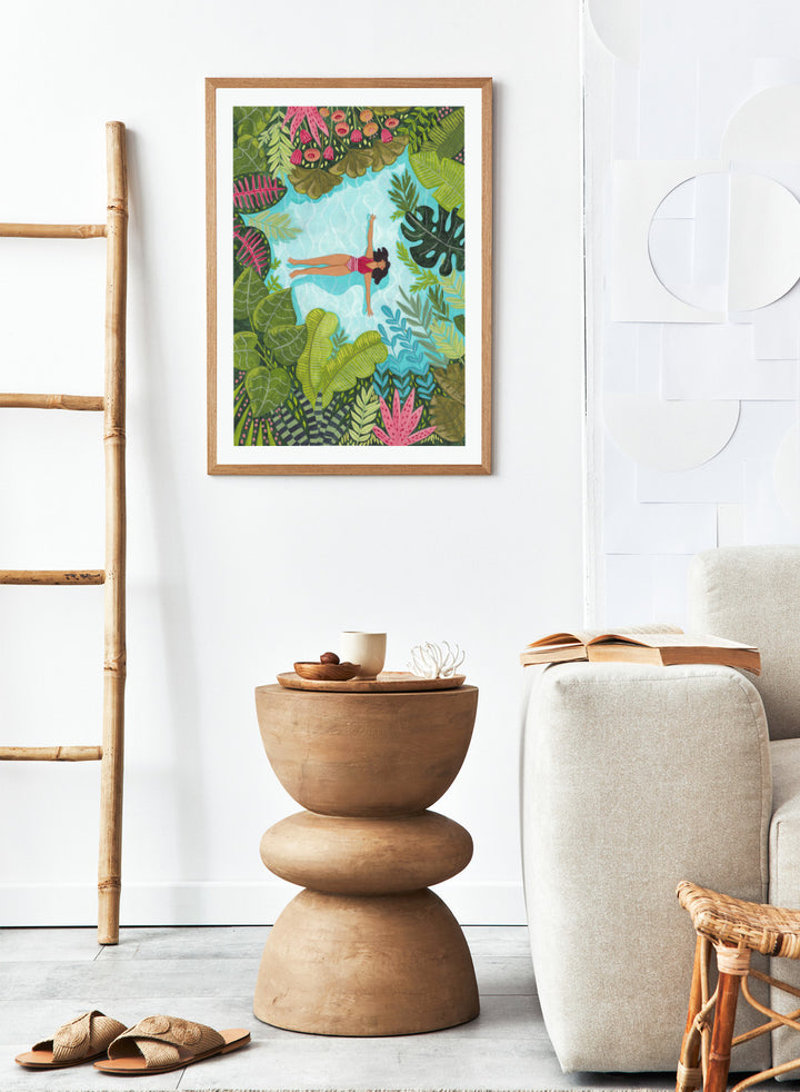 Illustration of a woman swimming in a pool surrounded by tropical plants. Tropical Pool Relaxation by Caroline Bonne Müller is a fine art print and wall poster of a woman floating in a pool surrounded by tropical plants.