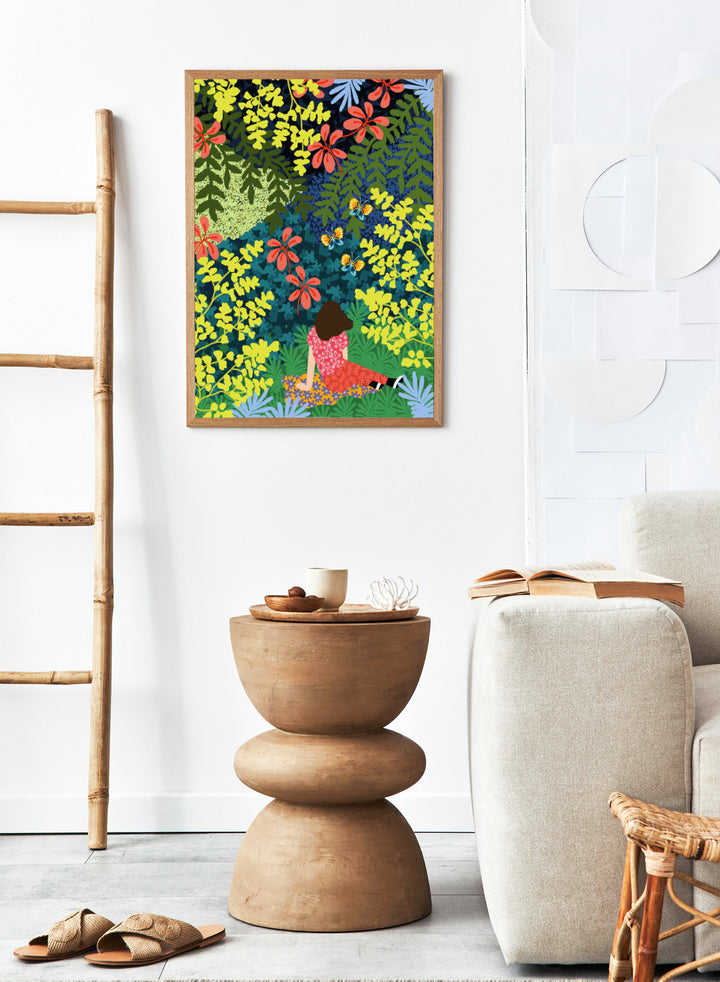 Illustration of a person sitting among colorful flowers and foliage. Picnic in the Forest by Rafaela Mascaro fine art print featuring lush botanical forest, oversized leaves, butterflies, modern colorful wall art poster.