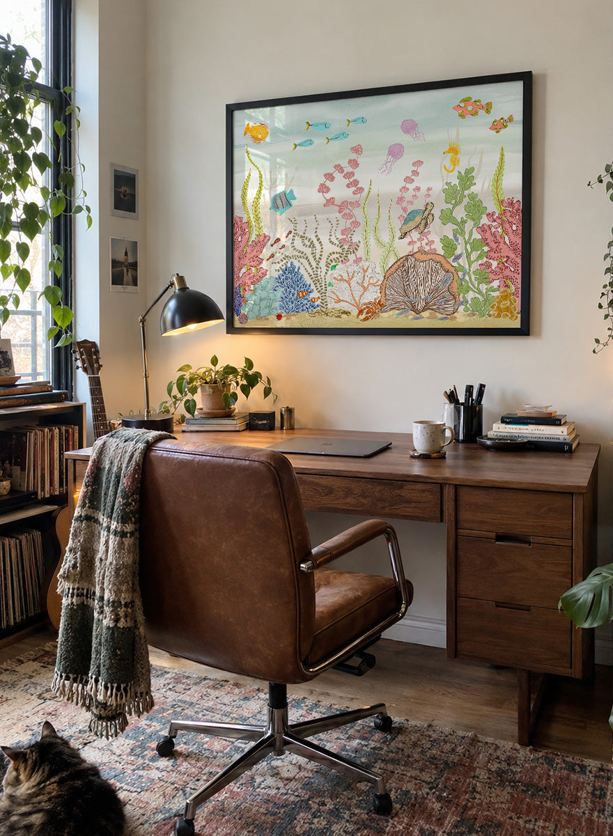 A framed art print depicting a colorful underwater scene with fish, coral, sea plants, a turtle, and a clam shell on a sandy ocean floor, shown against a light neutral background. Shop Vibrant Underwater World by Nikita Jariwala, an ocean wall art print poster with sea turtles, tropical fish, coral reef art, jellyfish, and blue tones.
