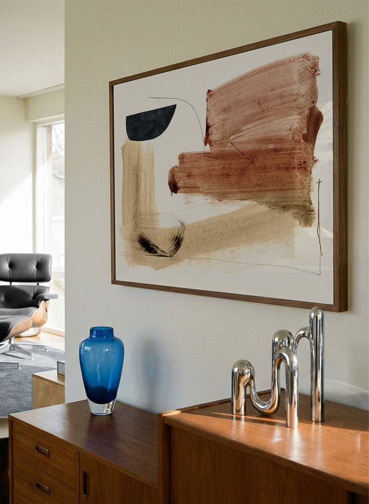 Abstract framed wall art featuring broad brushstrokes in terracotta, beige, black, and brown on a cream background. Shop Cooking by Dan Hobday, a warm abstract art print featuring rust brown, black, and sandy neutral forms with loose lines and layered brush texture.