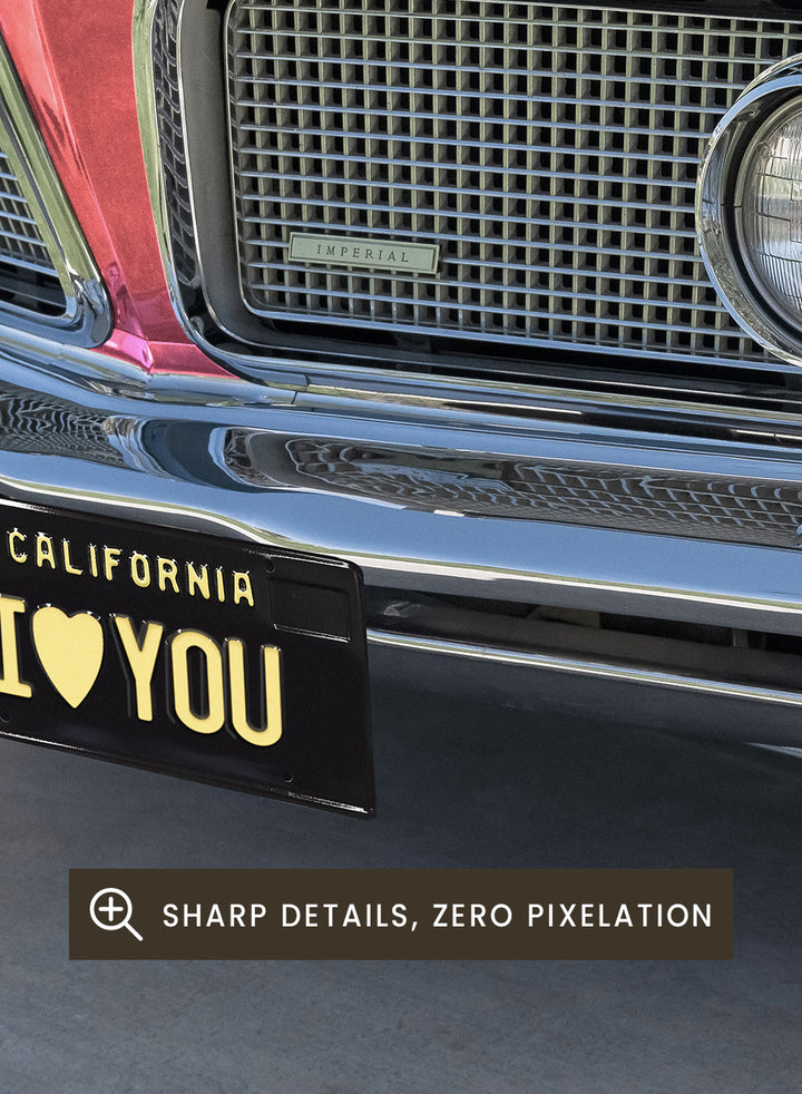 Pink vintage car with 'I ❤️ YOU' license plate against a pink sky. P.S. I Love You by Tom Windeknecht is officially licensed photography featuring a vibrant pop-art style photo of a car with romantic typography. Framed or unframed.