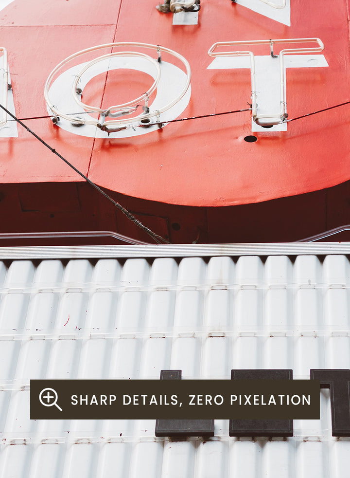 Vintage motel sign with 'Let Love In' message against a blue sky. Let Love In by Bethany Young features a vintage motel sign with red neon lettering against blue sky. Retro Americana photography wall art print.