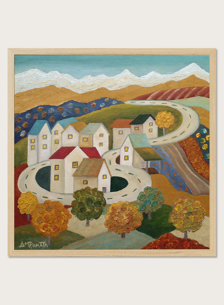 A framed folk-art style landscape painting depicting a village with white houses, winding roads, colorful trees, and mountains under a blue sky. Shop Autumn Road Village by Angeles M. Pomata, a colorful autumn landscape art print featuring a winding road, white village houses, fall trees, and distant mountains.