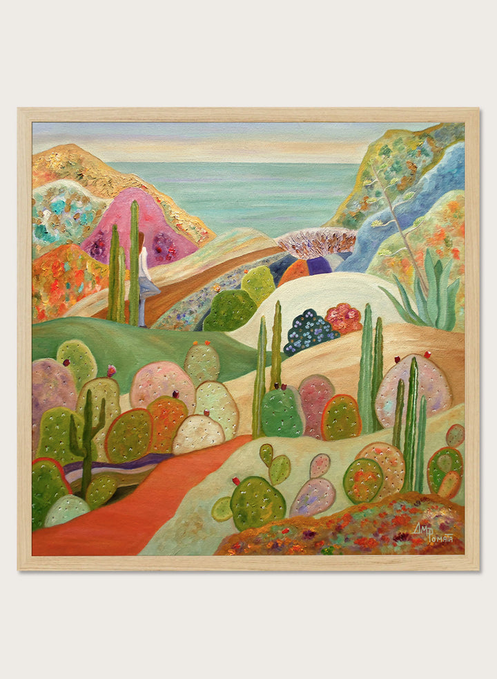 A framed colorful landscape painting featuring stylized cacti, hills, and a coastal scene. Shop Colorful Desert Yoga View by Angeles M. Pomata, a colorful desert landscape art print featuring cacti, rolling hills, a yoga figure, and coastal views.