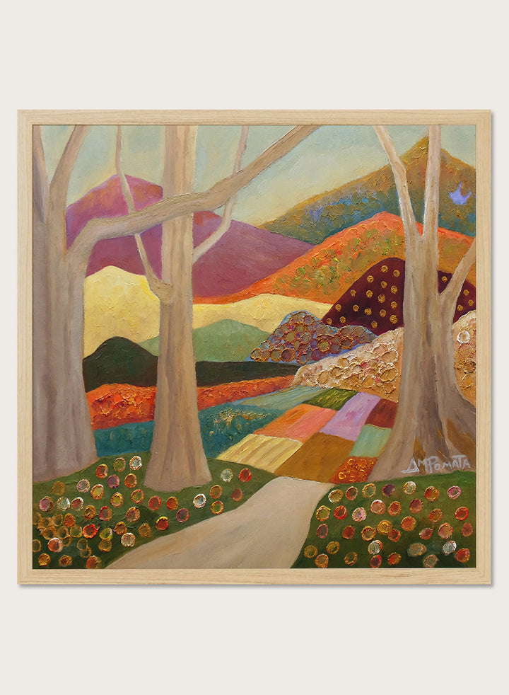 A framed landscape painting featuring stylized trees, a winding path, patchwork fields, and mountains in warm earthy tones. Shop Colorful Field Path by Angeles M. Pomata, an autumn landscape art print featuring a winding path, textured fields, flowers, and rolling countryside.