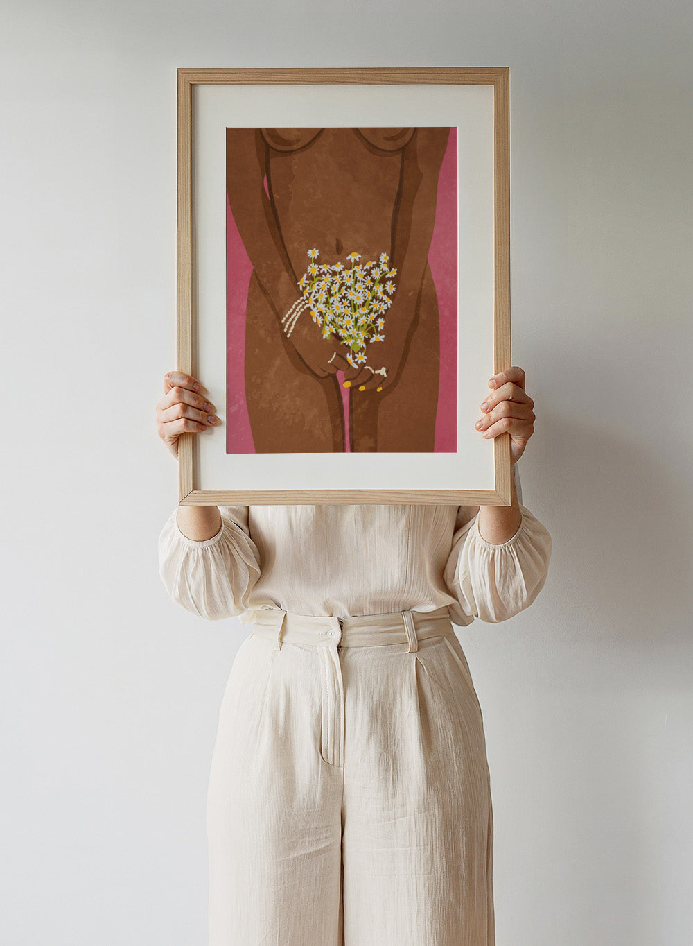 Illustration of a hand holding flowers against a brown background. Wearing Flowers by Raissa Oltmanns is a modern woman portrait art print with daisies, pink background, and minimalist graphic wall poster design.