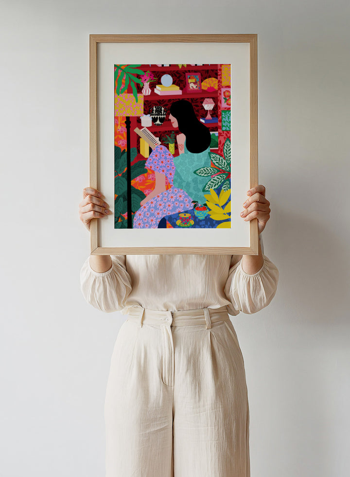 Illustration of a women sitting together with a colorful, patterned background. Girl Reading Her Favorite Book by Rafaela Mascaro fine art print poster featuring woman reading, red bookshelf, bold patterns, plants, modern contemporary wall art.