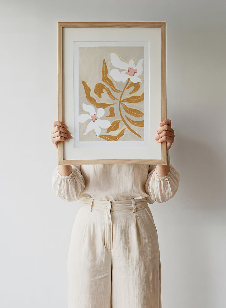 Decorative artwork with stylized flowers on a beige background. Flower Flower Flower by Arty Guava is a modern floral art print with oversized white blossoms and golden leaves. Officially licensed wall poster.
