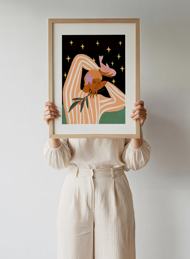 Illustration of a woman with flowers in her hair against a starry night sky. Balance by Arty Guava is a modern surreal woman art print with stars, stripes, and a pink fish. Officially licensed contemporary wall poster.