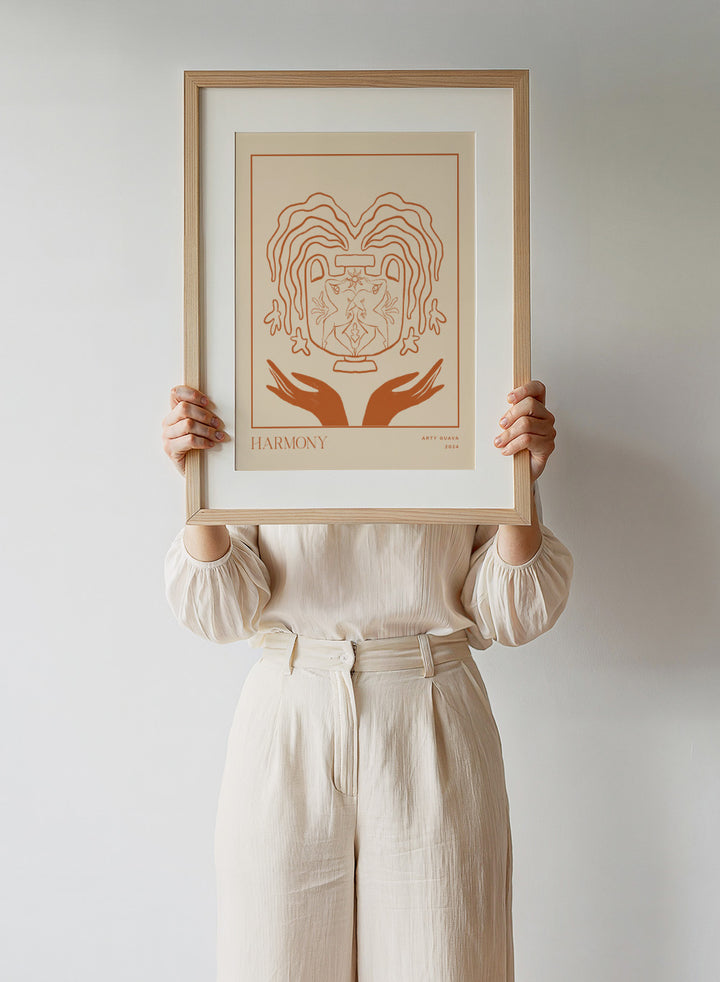 Artistic illustration of a heart with hands holding it, titled 'Harmony' by Arty Guava 2024. Harmony by Arty Guava is a minimalist vessel art print with terracotta linework, mirrored figures, and symbolic calm. Officially licensed wall poster.