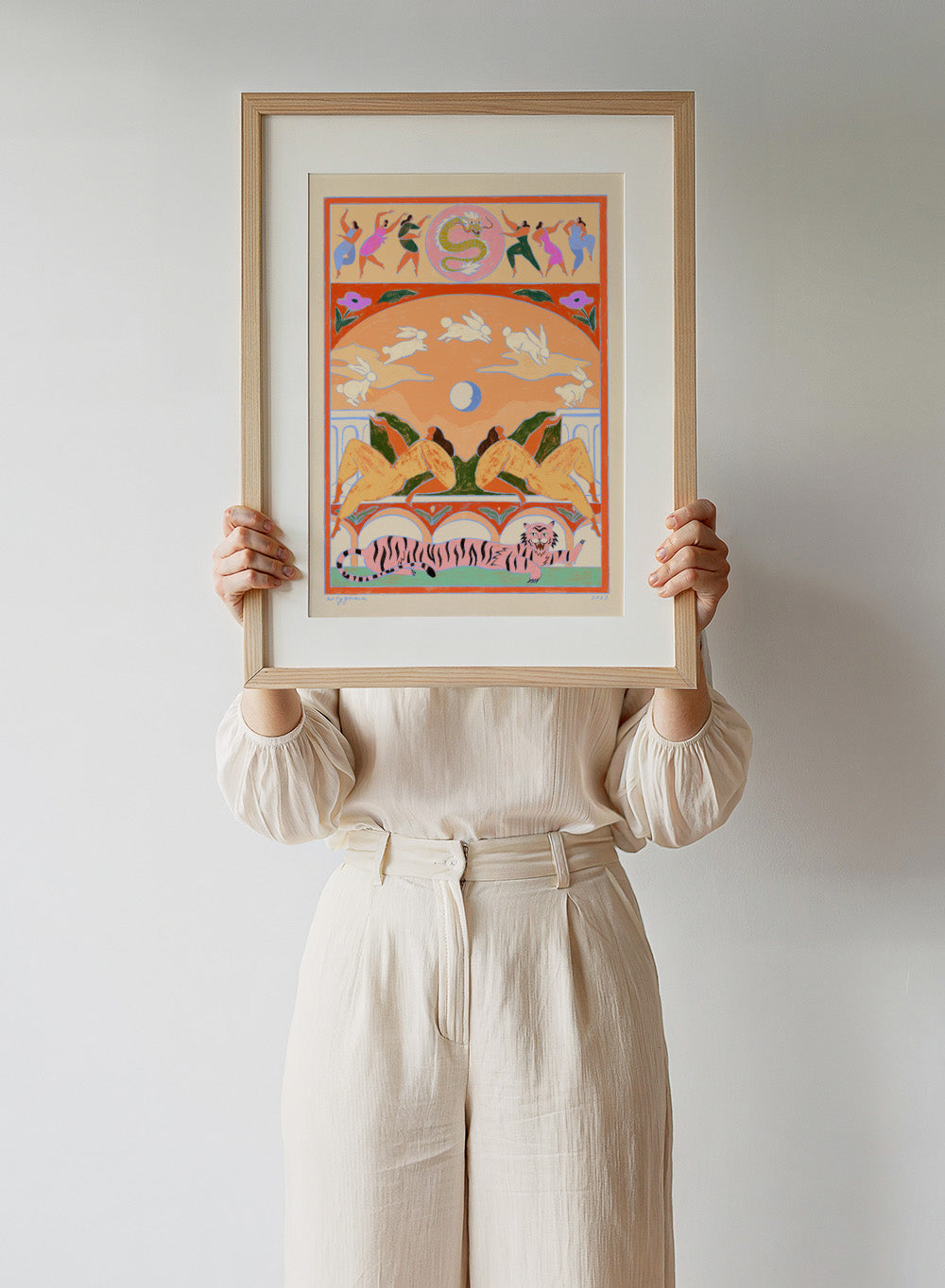 Decorative artwork with animals and people in a stylized setting. Rabbit Jumps Over the Moon by Arty Guava is a surreal art print with rabbits, dancers, and a tiger in bold color. Officially licensed wall poster.