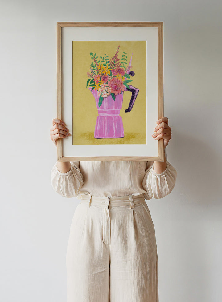 Colorful floral arrangement in a pink vase on a yellow background. Espresso Maker with Flowers by Raissa Oltmanns is a modern floral fine art print featuring a pink moka pot vase still life and bold kitchen wall decor poster.