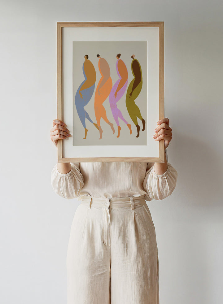 Abstract illustration of four stylized figures in various colors on a beige background. We The Giants by Arty Guava is a modern art print of four bold figures walking together, celebrating strength and sisterhood. Officially licensed wall poster.