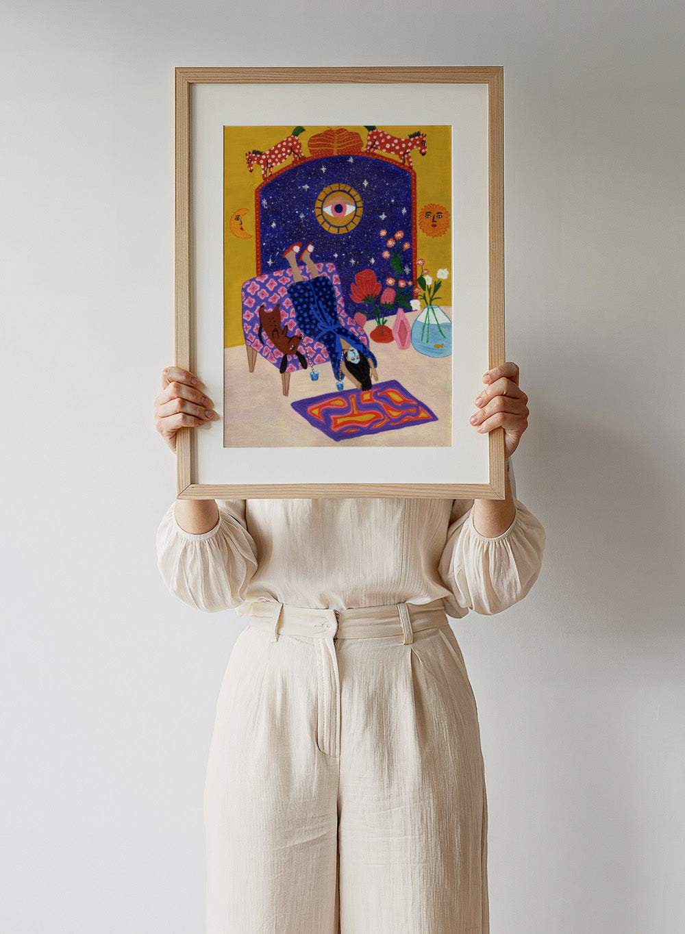 Colorful artwork of a person sitting on a chair with animals and decorative elements. Day Off From Office by Jota de Jai is a whimsical modern art print of a woman upside down with her dog, mid skincare routine, officially licensed wall poster with framing.
