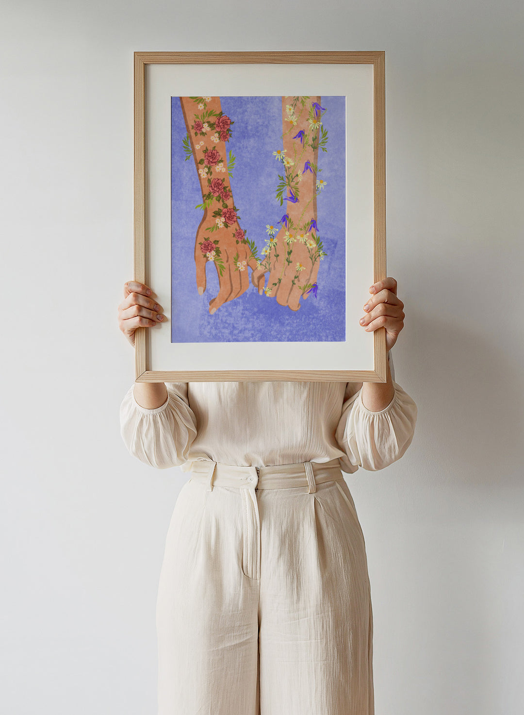 Illustration of two hands holding each other with floral designs on a blue background. Holding Hands by Raissa Oltmanns is a modern romantic fine art print featuring floral arms illustration and contemporary love wall decor poster.