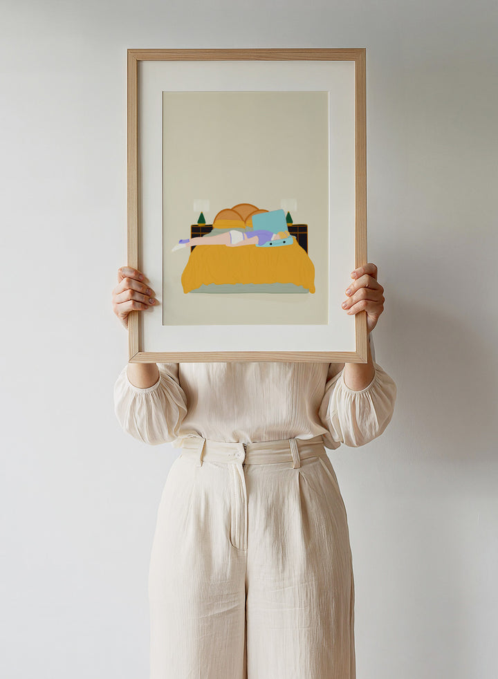 Illustration of a person lying in bed with a blue pillow and yellow blanket on a beige background. Digital Nomad by Jota de Jai is a calm modern art print of a woman resting on a bed with an open suitcase, officially licensed fine art wall poster with framing available.