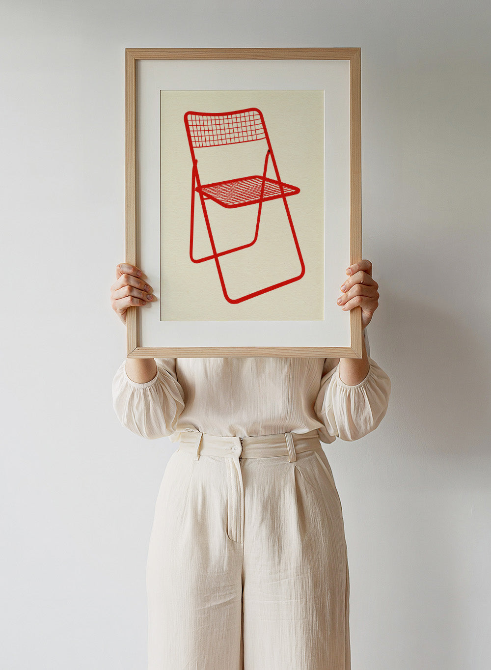 Red metal chair on a beige background. Modern chair wall art print by Rosi Feist featuring a bold red wire net chair illustration. Contemporary minimalist poster for design lovers.