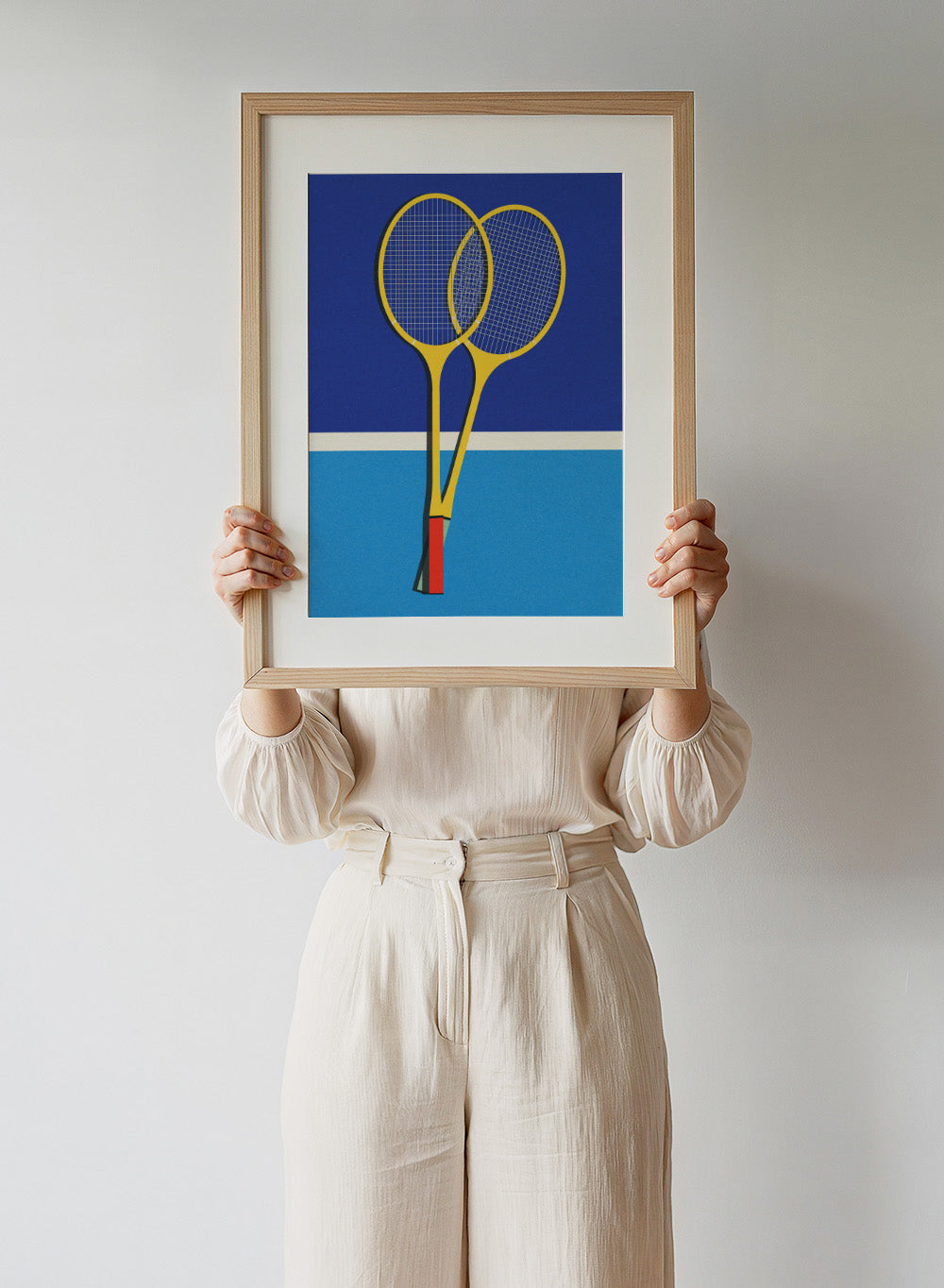 Two yellow badminton rackets on a blue background with a white stripe at the bottom. Wooden Badminton Rackets by Rosi Feist is a modern minimalist fine art print featuring bold yellow rackets on a graphic blue court. Officially licensed wall poster with optional artisan framing.