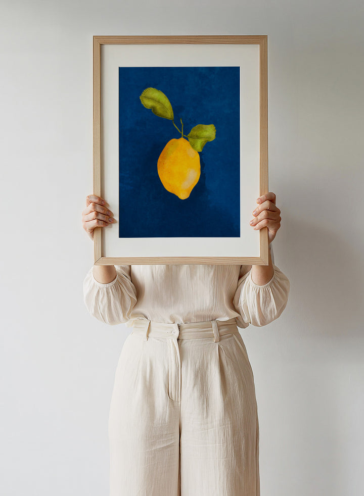Just a Little Lemon by Raissa Oltmanns is a modern lemon art print featuring a bold yellow citrus still life on deep blue wall poster design.