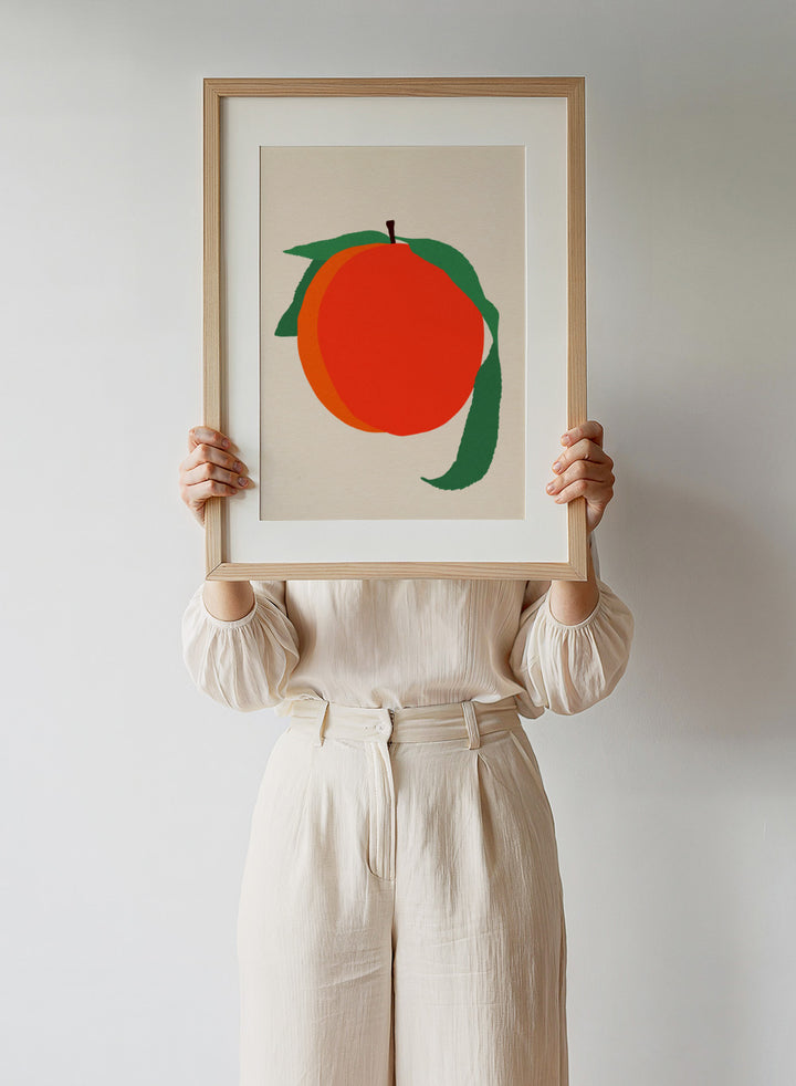Illustration of a peach with green leaves on a beige background. Peach by Rosi Feist is a modern minimalist fruit art print with bold color and Bauhaus-inspired graphic design. Officially licensed fine art poster with framing.