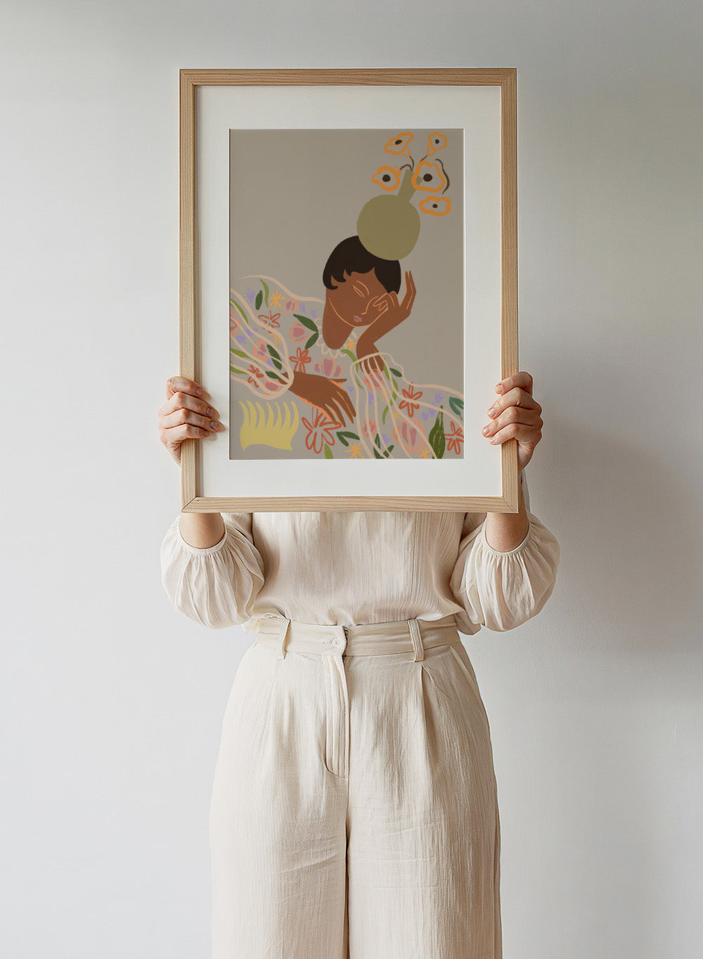 Illustration of a person with a flower on their head against a beige background. The Overthinker by Arty Guava is a modern woman illustration art print with soft florals and warm tones. Officially licensed wall poster with framing.