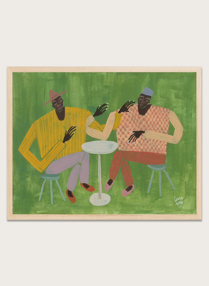 Framed artwork of two people sitting at a table on a green background. In Good Company by Studio IMO (Ibi Meier-Oruitemeka) is a modern figurative art print featuring two figures at a table in a bold contemporary wall poster design.