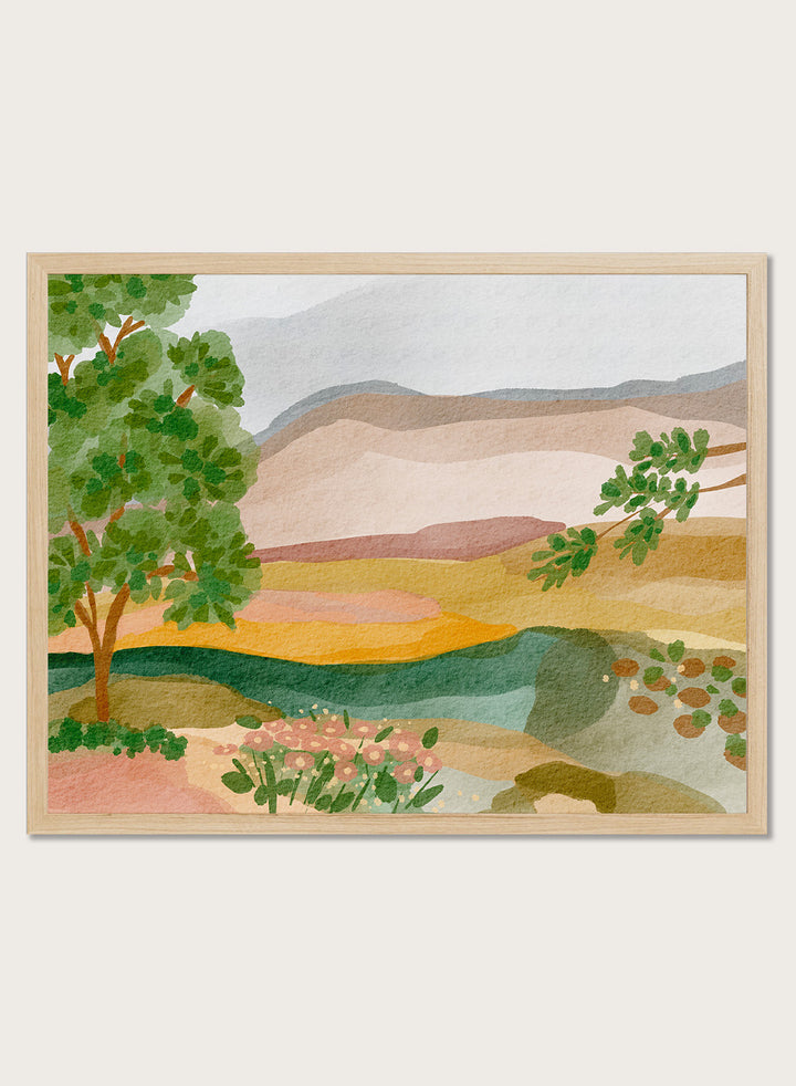 A framed landscape art print featuring a stylized watercolor scene with green trees, layered hills, and a river. Shop Peaceful Valley View by Nikita Jariwala, a serene landscape wall art print poster featuring rolling hills, distant mountains, wildflowers, and soft green tones.