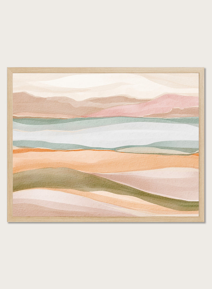 Framed abstract landscape art print featuring soft watercolor hills and layered fields in pastel peach, pink, sage green, cream, and light blue. Shop Calm Watercolor Landscape by Nikita Jariwala, an abstract landscape wall art print poster with rolling hills, mountain scenery, watercolor layers, and soft green tones.