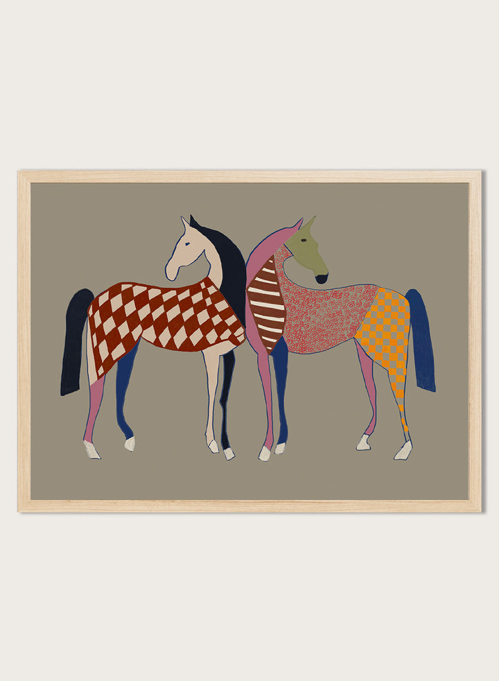 A framed art print featuring two stylized horses with colorful geometric patterns, set against a solid taupe background. Colorful Patterned Horses by The Art Concept animal art print featuring two horses with checks, stripes, florals, and bold playful color.