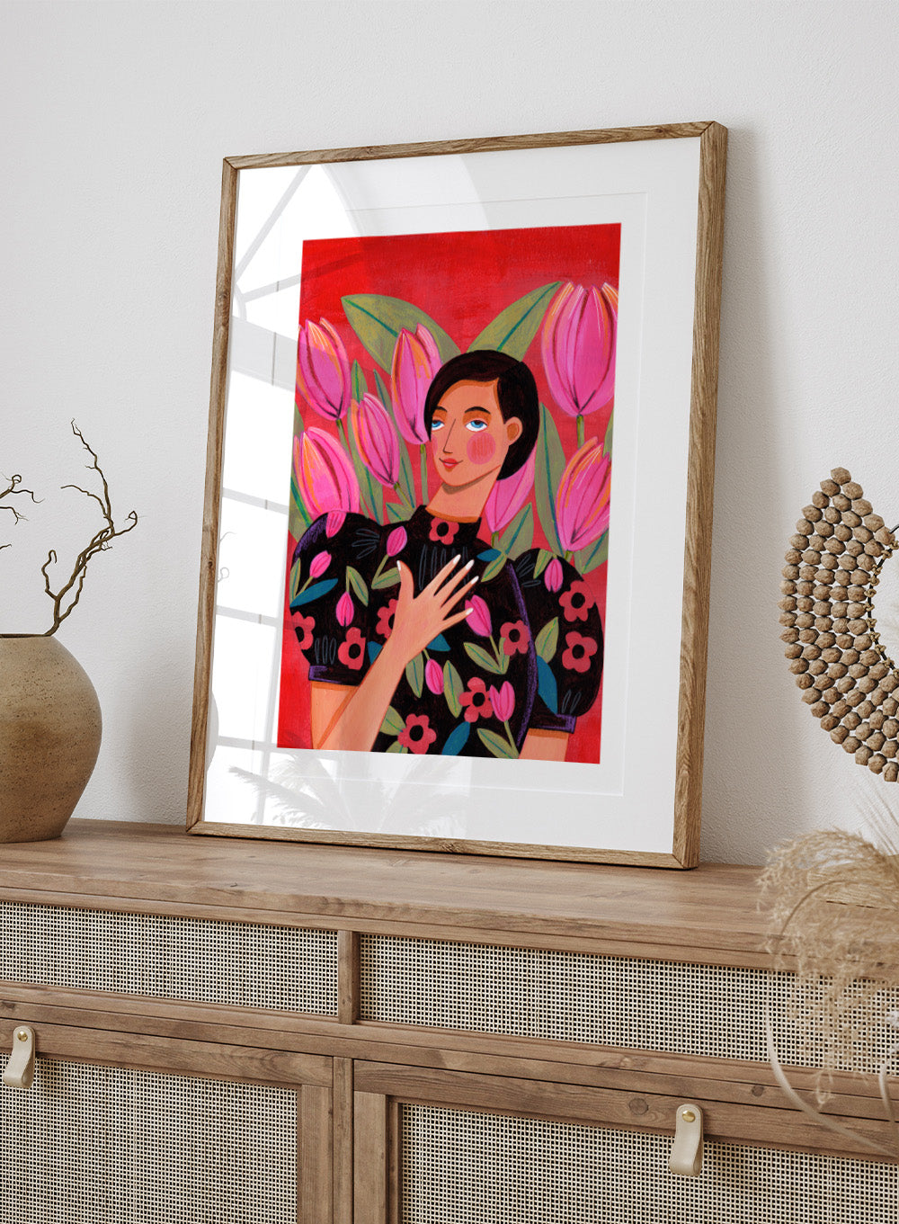 Illustration of a woman with floral dress and pink tulips on a red background. Woman portrait art print surrounded by pink tulips on a red background by Caroline Bonne Müller. Colorful floral illustration wall poster, officially licensed.