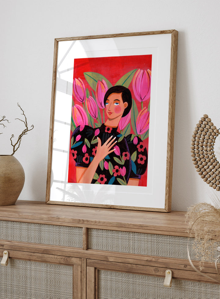Illustration of a woman with floral dress and pink tulips on a red background. Woman portrait art print surrounded by pink tulips on a red background by Caroline Bonne Müller. Colorful floral illustration wall poster, officially licensed.