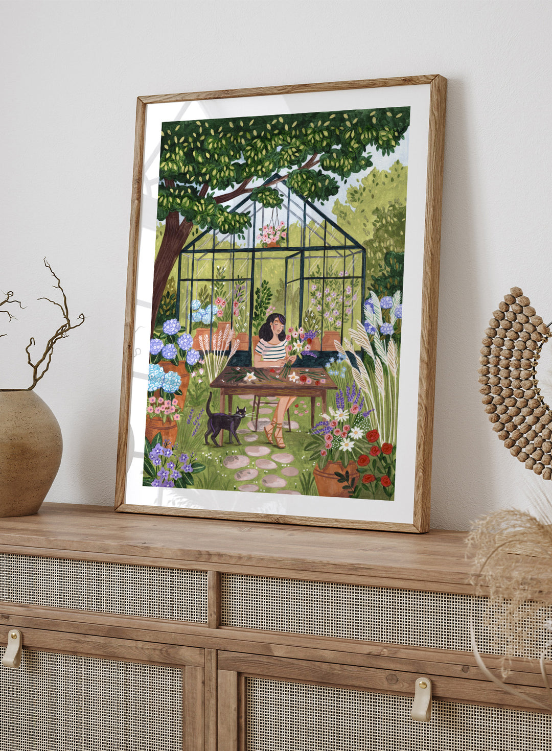 Garden Flower Arranging by Caroline Bonne Müller is a floral garden art print featuring greenhouse, woman arranging flowers, cat illustration, and modern aesthetic botanical scene.