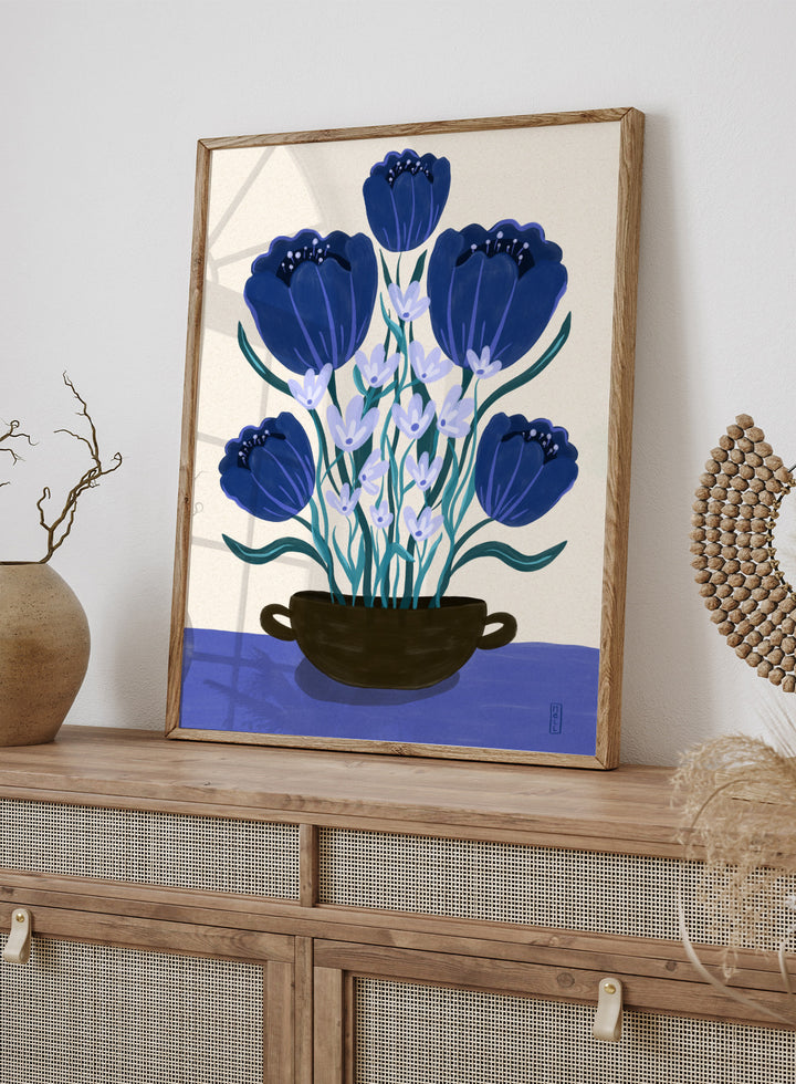 Artistic depiction of blue flowers in a black pot on a beige background. Blue Floral Arrangement by Dirkie Nell is a botanical floral art print featuring deep blue flowers, folk inspired illustration, modern wall art, and expressive hand painted details.