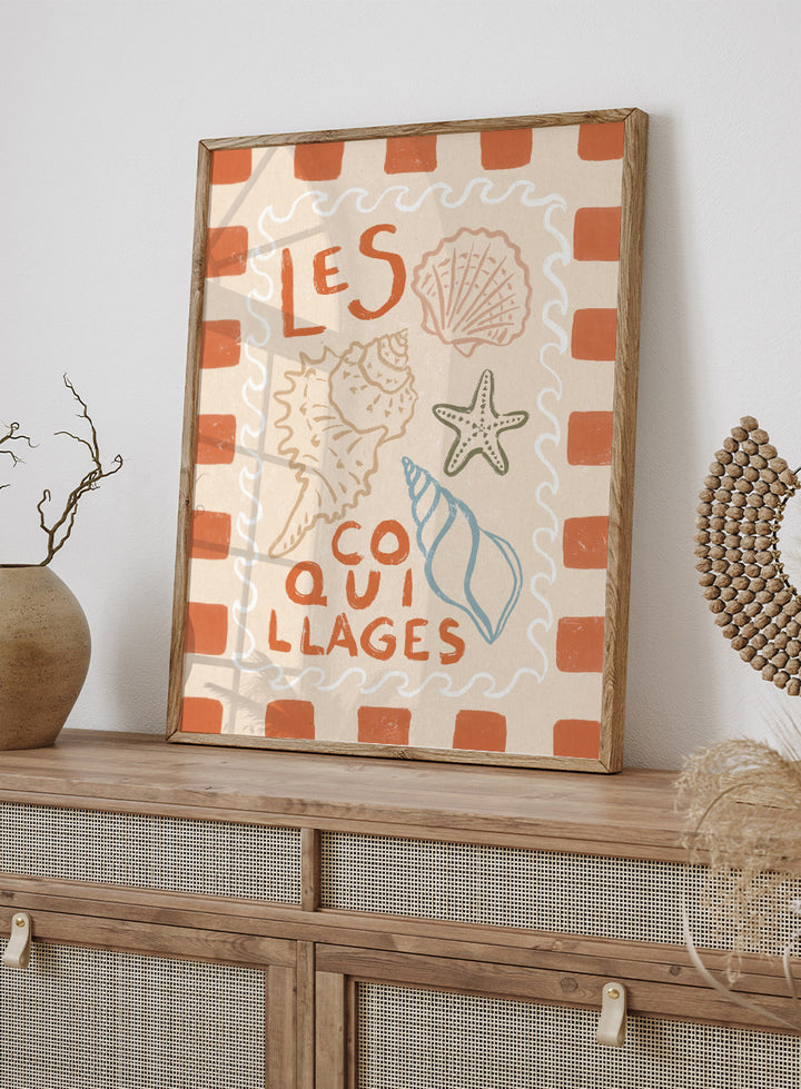 A square decorative print or card with the French text “LES COQUILLAGES” in orange lettering, surrounded by illustrated seashells and a starfish on a cream background with an orange-and-white check border. Rustic French Seashells by Katarzyna Gąsiorowska coastal art print with hand-drawn shells, a starfish, French lettering, and terracotta checks.