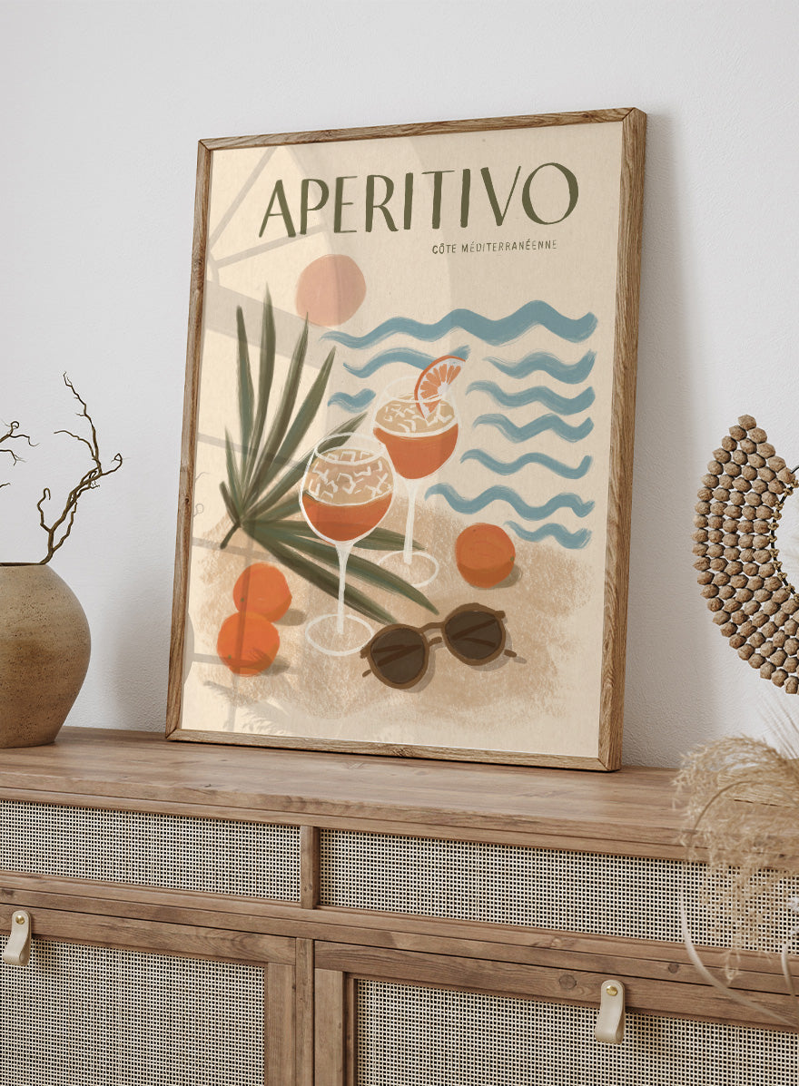 A travel-style poster reading “APERITIVO” with “CÓTE MEDITERRANÉENNE” beneath it, showing illustrated cocktails, citrus fruits, palm leaves, blue ocean waves, and sunglasses on a warm beige background.Aperitivo Beach Day by Katarzyna Gąsiorowska Mediterranean art print featuring spritz cocktails, oranges, sunglasses, and vintage coastal style.
