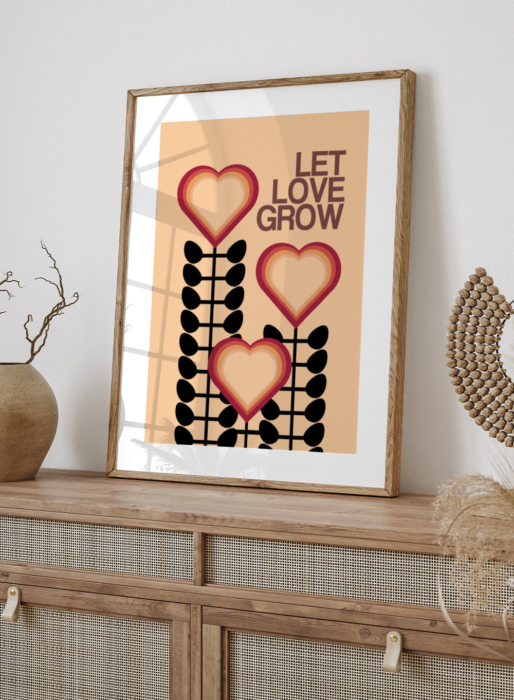 Decorative poster with hearts and leaves on a beige background with 'Let Love Grow' text. Let Love Grow by Frances Collett art print featuring heart-shaped flowers, bold stems, and retro colors. Officially licensed wall poster with optional framing.