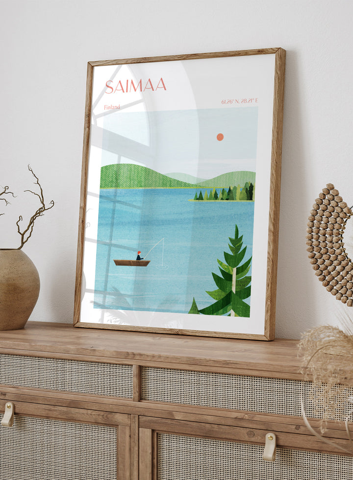 Illustration of a lake scene with a person fishing, surrounded by greenery and mountains, with 'Saimaa, Finland' text at the top. Calm Saimaa Lake Fishing by Longwayhome is a minimalist Scandinavian landscape art print featuring peaceful Finland lake scenery, forest views, and modern Nordic design.