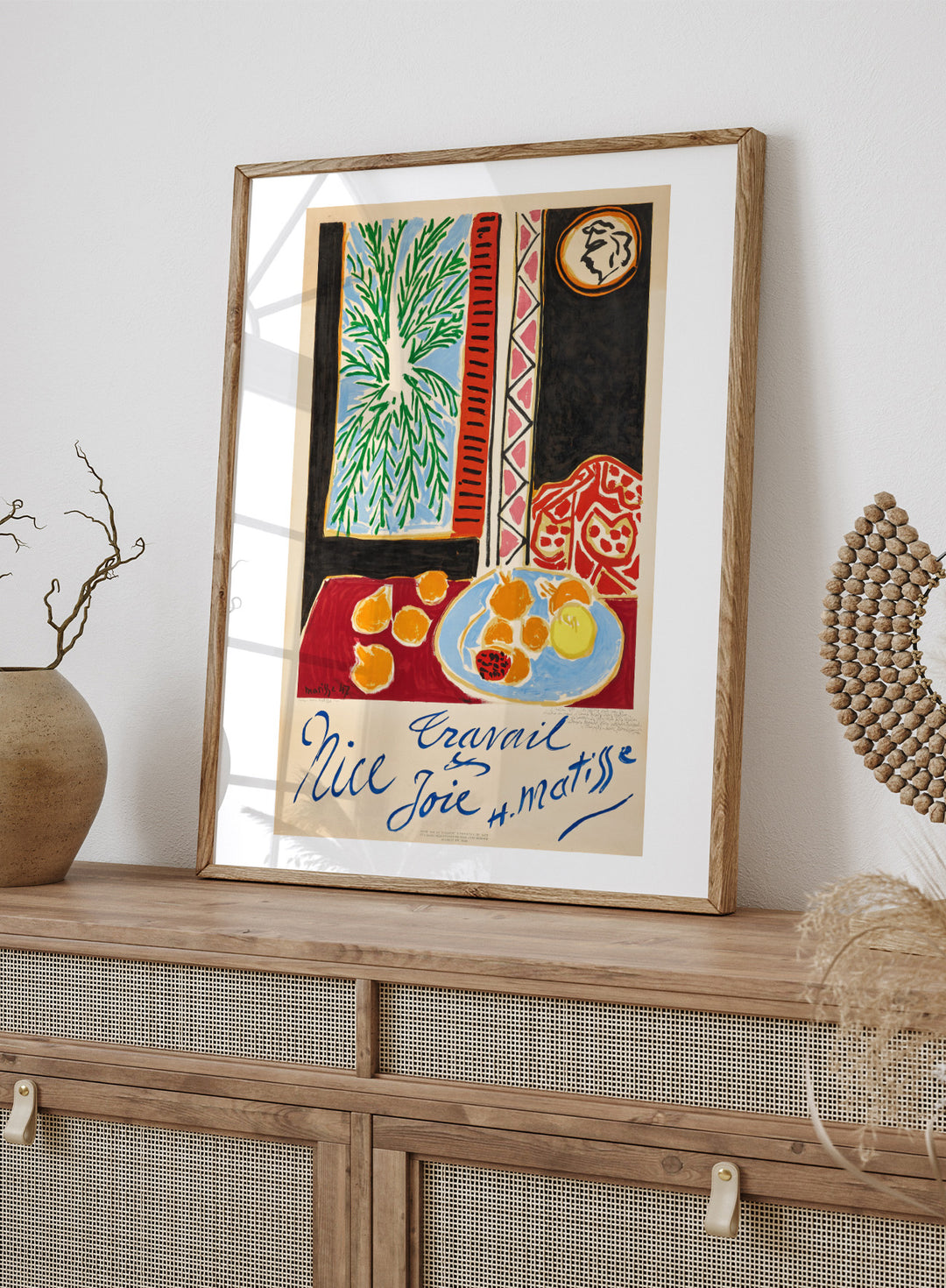 Colorful artwork with a table setting, oranges, and abstract elements on a beige background. Nice, Travail et Joie by Henri Matisse is a colorful 1947 art print featuring Mediterranean interiors, expressive linework, fruit still life details, and modern French design.