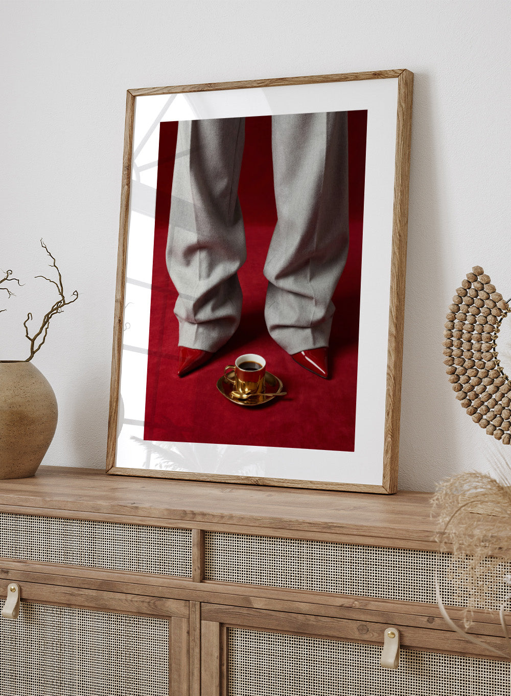 White pants with red shoes on a red carpet, featuring a gold cup and saucer with coffee. Red Shoes and Coffee by Andreas Magnusson is a fashion photography art print featuring red heels and espresso. Officially licensed modern wall poster.